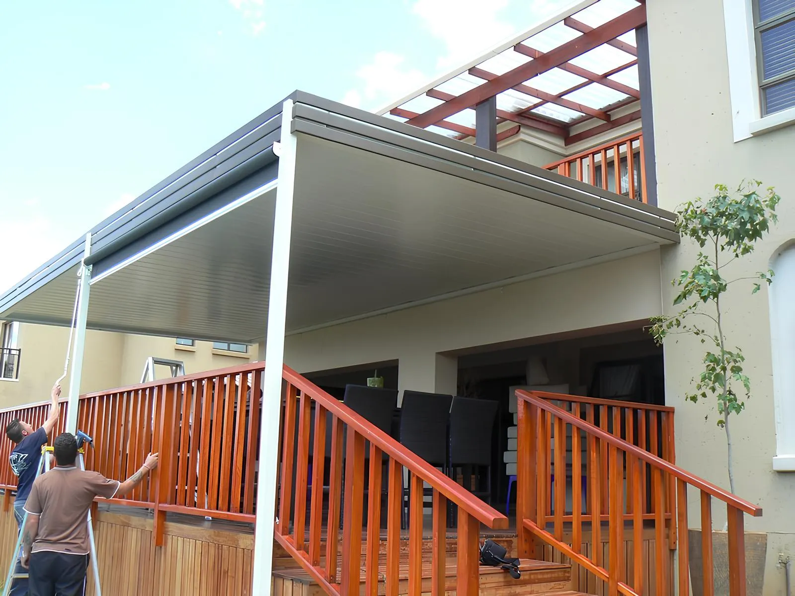 Flat white aluminium panel ceiling with a built-in box gutter over an entertainment patio