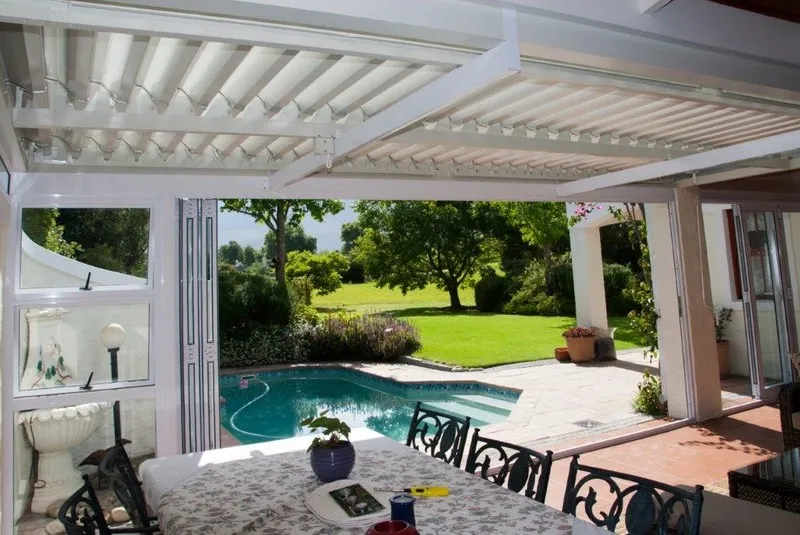 Adjustable louvre awning over a family entertainment patio
