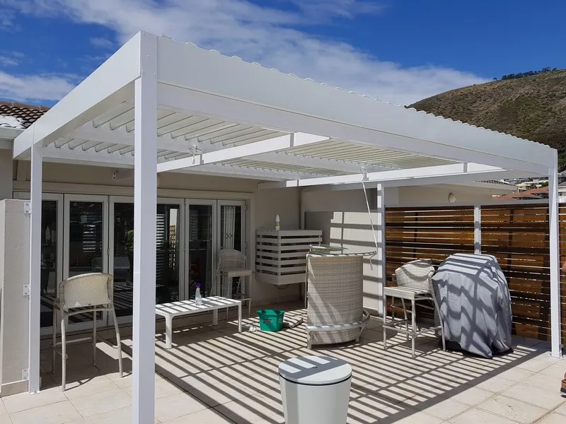 Adjustable louvre awning braced against coastal wind